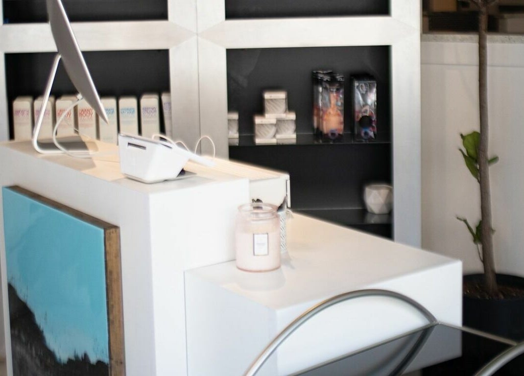 Welcoming front desk at BeeQ Downtown A2, Ann Arbor, Michigan, US, with modern decor and products displayed.