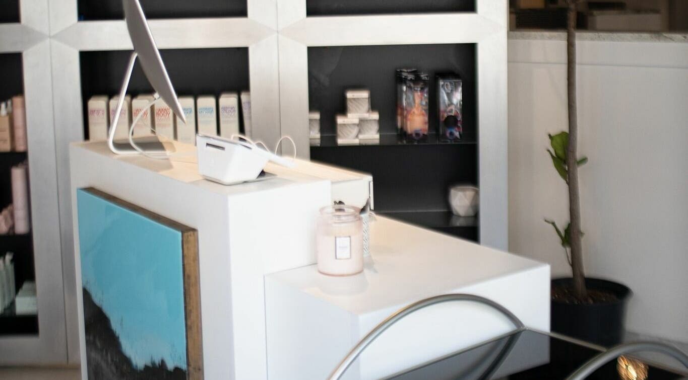 Welcoming front desk at BeeQ Downtown A2, Ann Arbor, Michigan, US, with modern decor and products displayed.