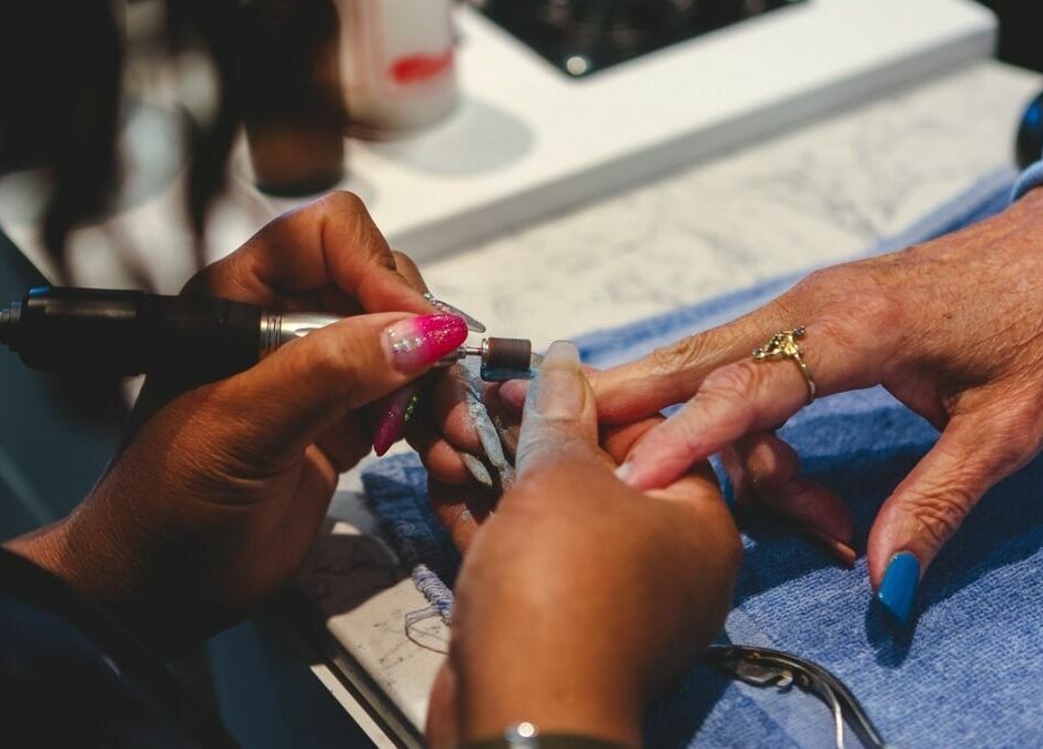 Nail technician beautifies nails at BeeQ Downtown A2, Ann Arbor, Michigan, US.