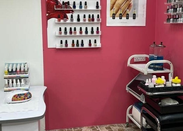 Nail salon display at Al Nahlah Ladies Saloon, Sharjah with polish bottles on pink walls.