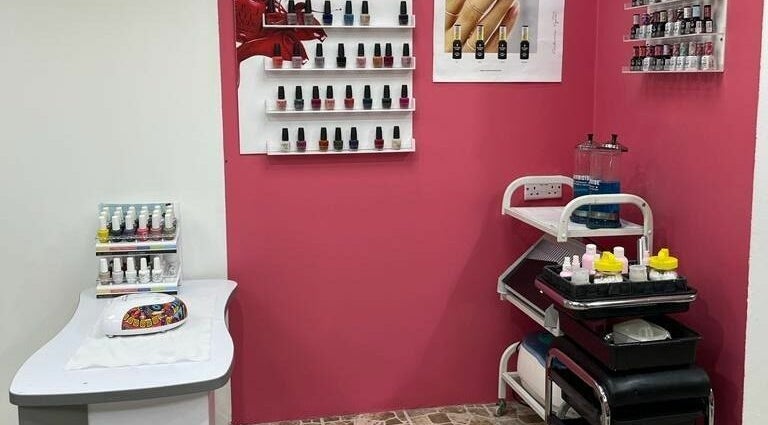 Nail salon display at Al Nahlah Ladies Saloon, Sharjah with polish bottles on pink walls.