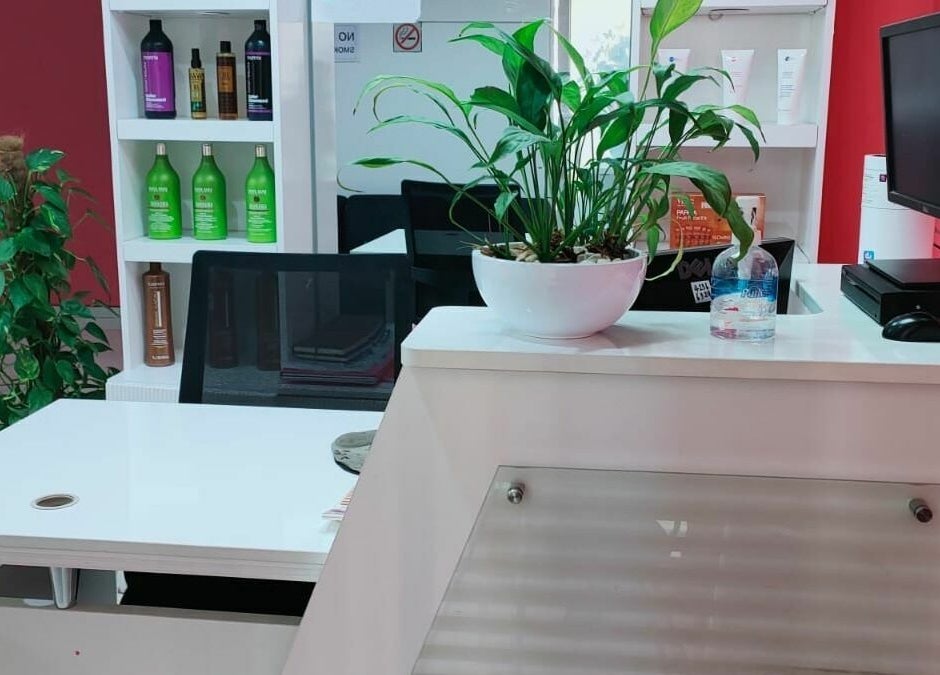 Chic reception desk at Al Nahlah Ladies Saloon in Sharjah, Sharjah, AE with plants and beauty products displayed.