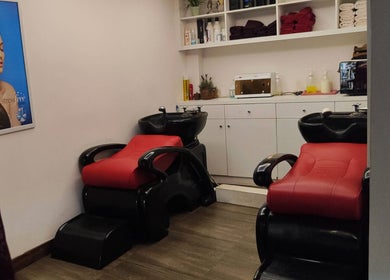 Cozy hair washing area at Shang Nyai Salon & Spa, Daerah Khusus Ibukota Jakarta, with red chairs and shelves.