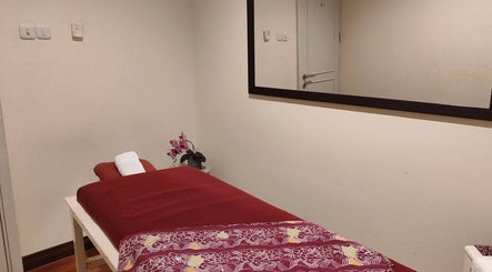 Cozy massage room at Shang Nyai Salon & Spa, Daerah Khusus Ibukota Jakarta, featuring a red massage table.