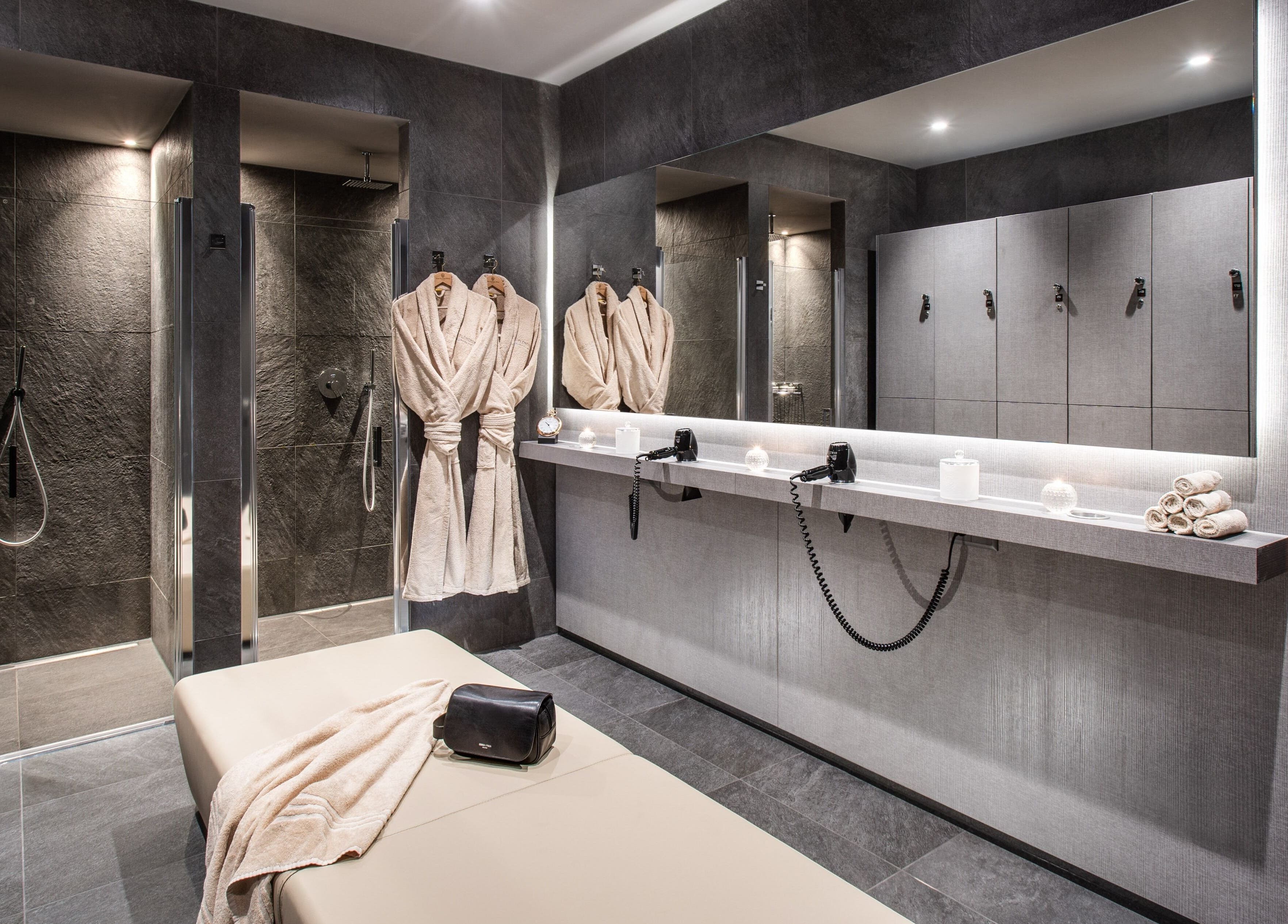 Elegant spa room at Hotel Splendide Royal, Lugano, Ticino, CH with robes, showers, and massage table.