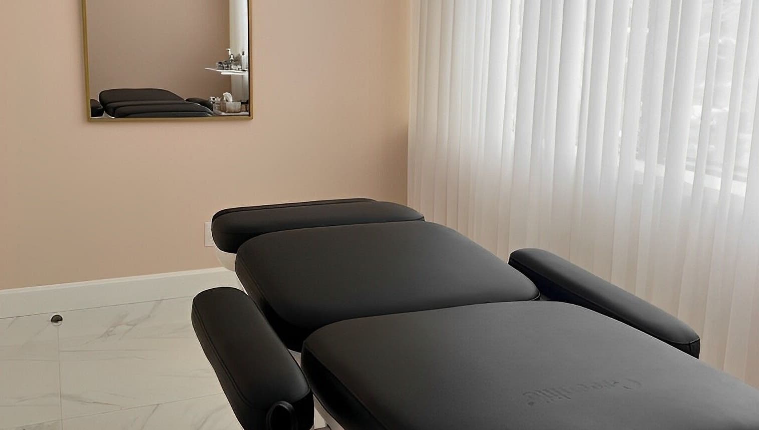 Relaxing treatment room at Dolly Lash Lounge, Pointe-Claire, Québec, CA, showcasing a comfortable black massage bed.