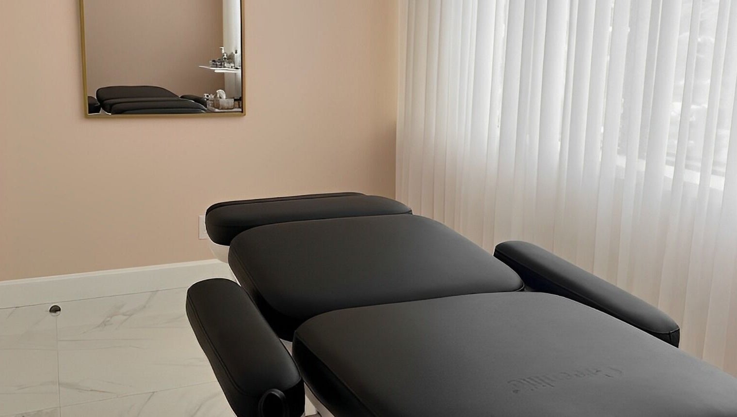Relaxing treatment room at Dolly Lash Lounge, Pointe-Claire, Québec, CA, showcasing a comfortable black massage bed.