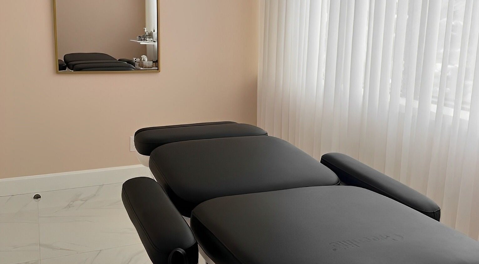 Relaxing treatment room at Dolly Lash Lounge, Pointe-Claire, Québec, CA, showcasing a comfortable black massage bed.