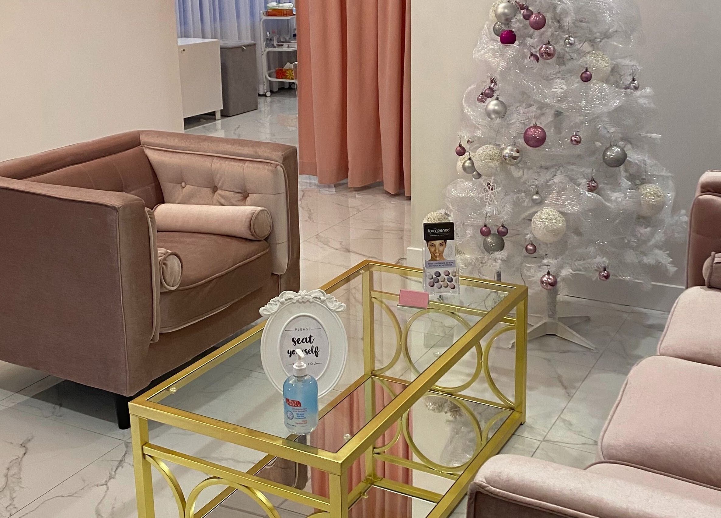 Elegant sitting area at Dolly Lash Lounge, Pointe-Claire, Québec, CA, featuring plush chairs and festive decor.