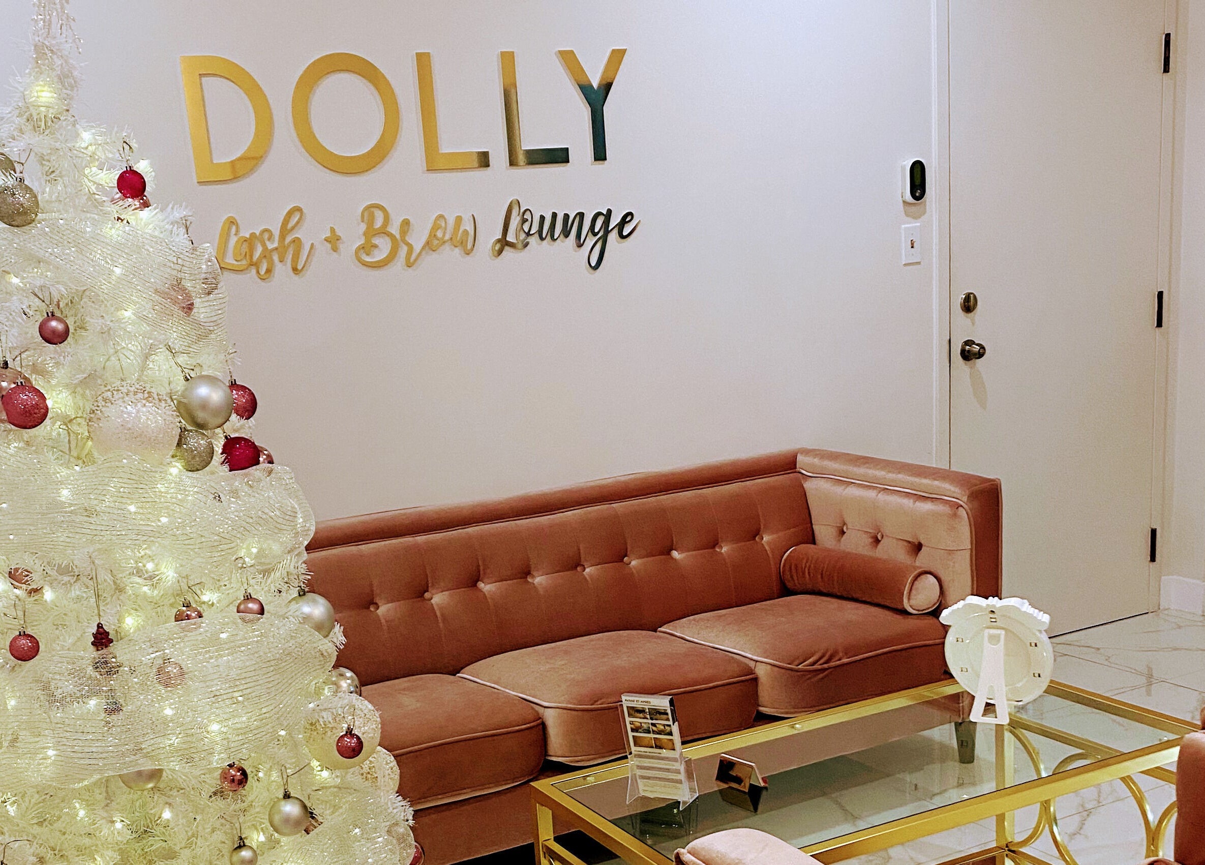 Cozy seating area with decorative Christmas tree at Dolly Lash Lounge in Pointe-Claire, Québec, CA.