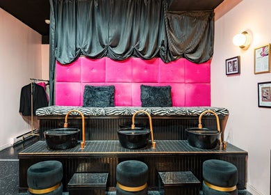 Coin pédicure chic à Candy Nail Bar, Montréal, Québec, CA, avec sièges roses et bacs noirs élégants.