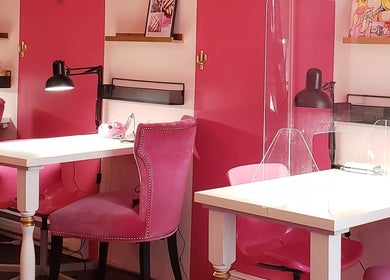 Intérieur vibrant de Candy Nail Bar, Montréal, Québec, CA, avec des chaises roses élégantes et des postes de travail modernes.