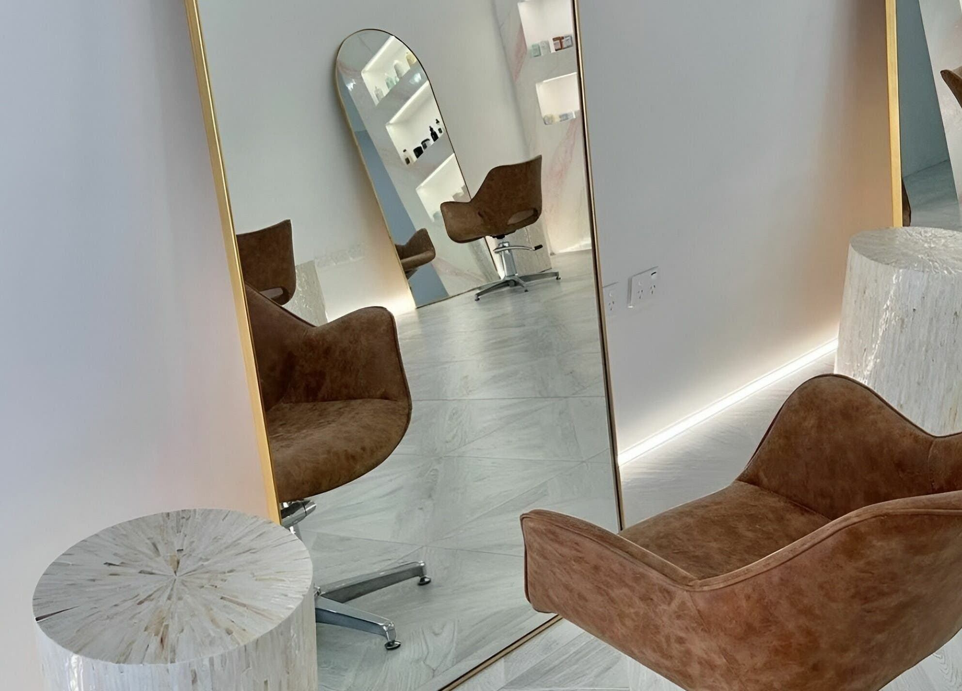 Stylish waiting area at Capelli and Co, The Entrance, New South Wales, AU featuring elegant mirrors and chairs.