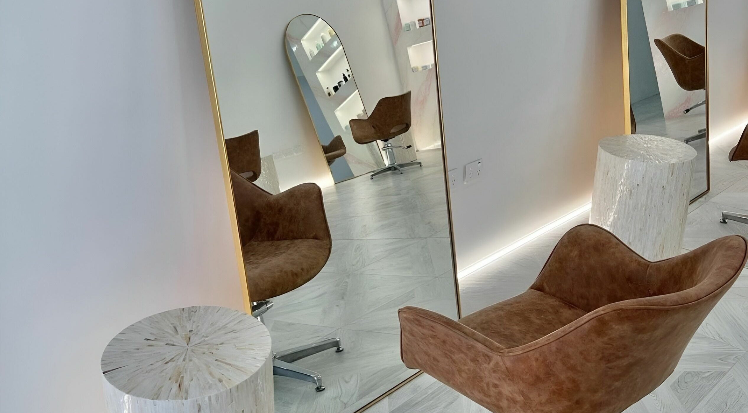 Stylish waiting area at Capelli and Co, The Entrance, New South Wales, AU featuring elegant mirrors and chairs.