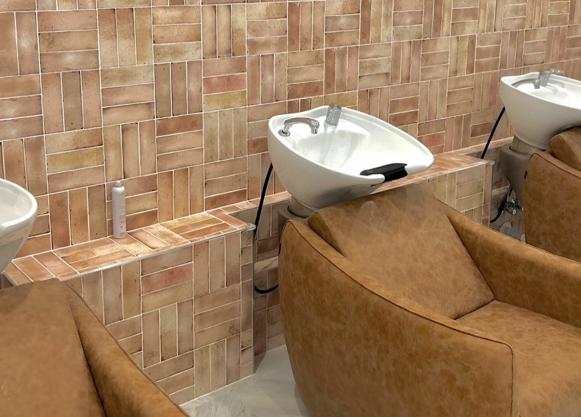 Luxury wash basins and brown leather chairs at Capelli and Co, The Entrance, New South Wales, AU.