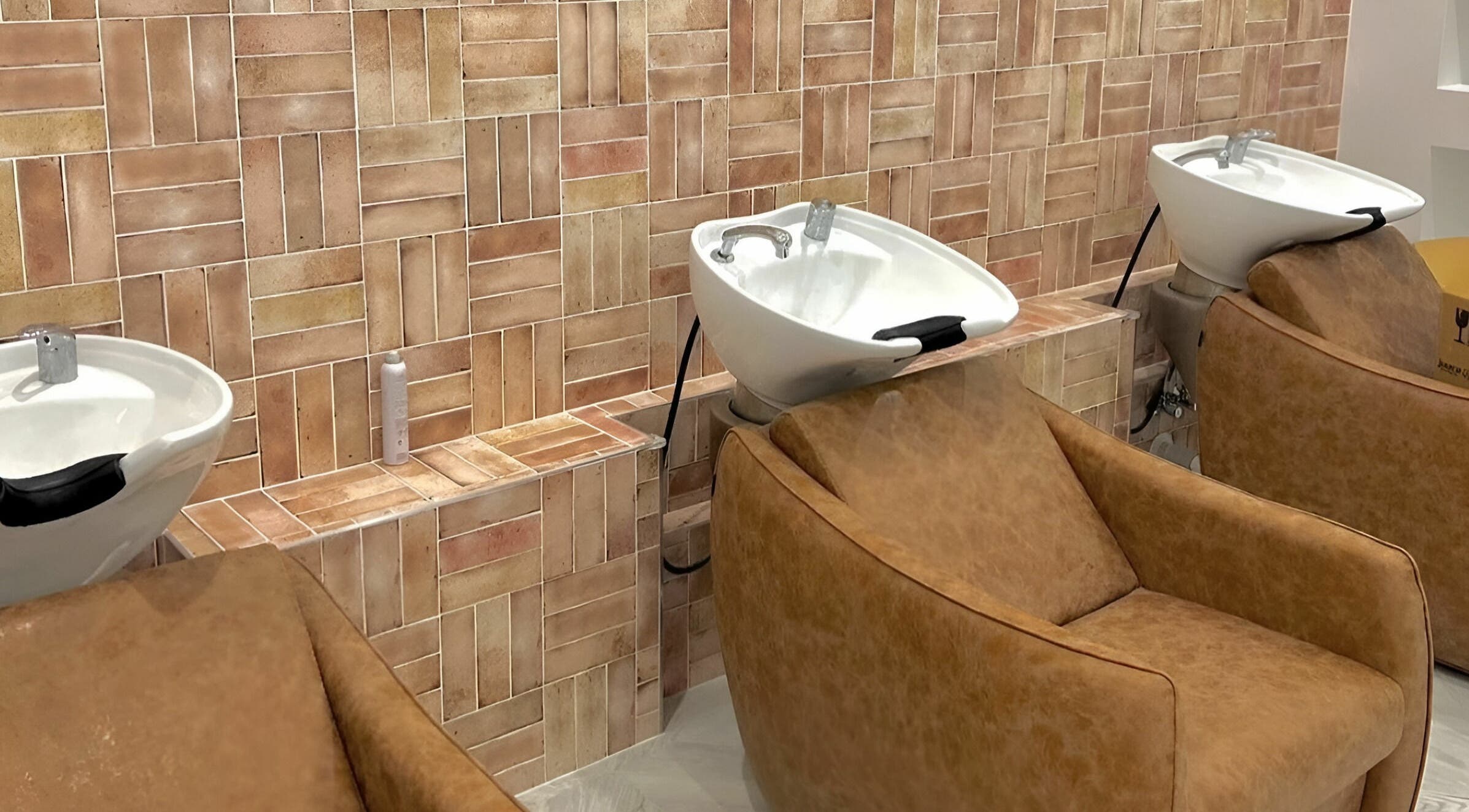 Luxury wash basins and brown leather chairs at Capelli and Co, The Entrance, New South Wales, AU.