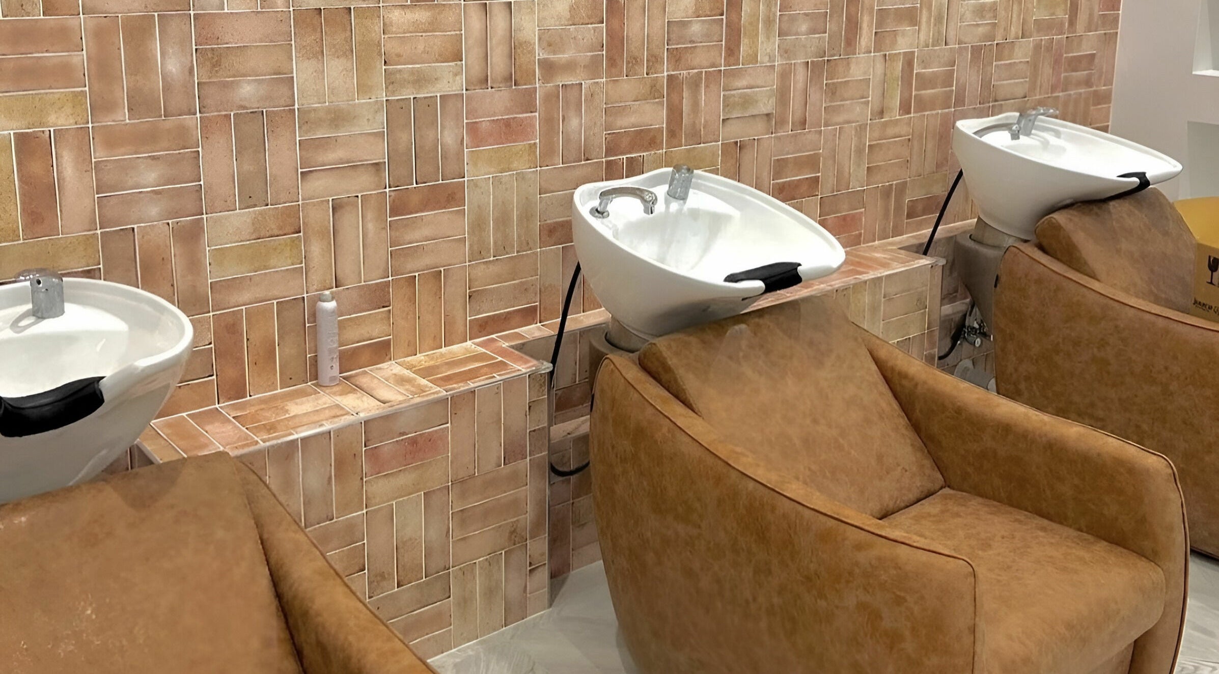 Luxury wash basins and brown leather chairs at Capelli and Co, The Entrance, New South Wales, AU.