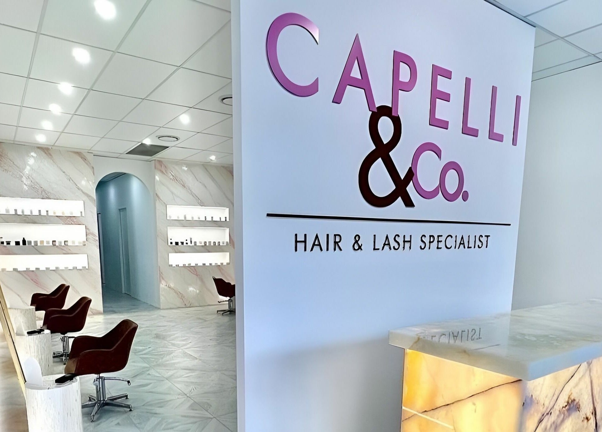 Stylish salon interior at Capelli and Co, The Entrance, New South Wales, AU, featuring chic seating and decor.