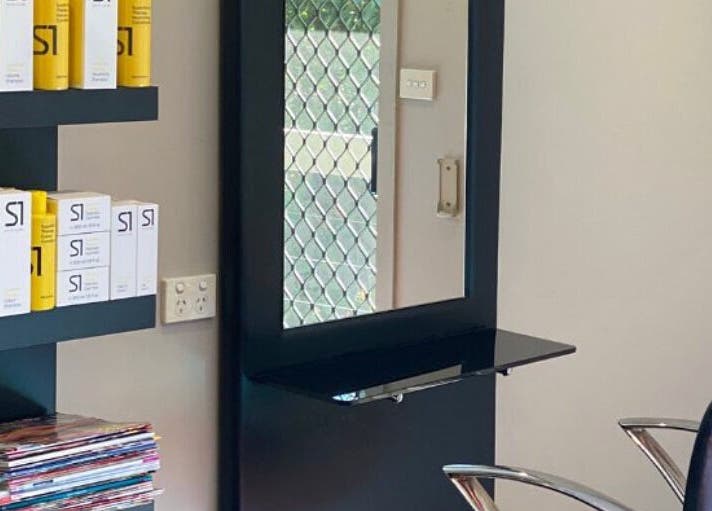 Interior view of Hair By Megan in Latham, AU featuring a stylish salon setup with shelves and products.