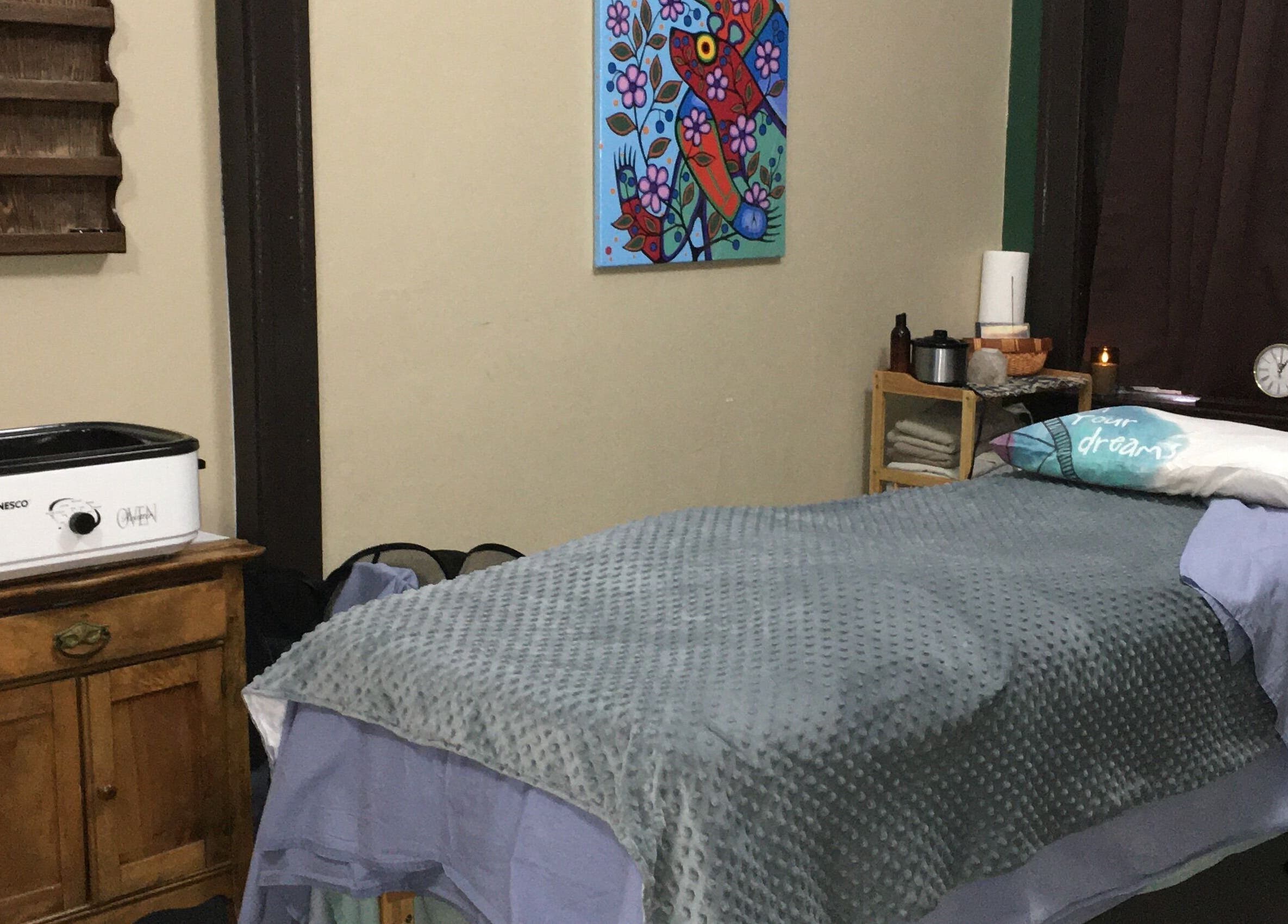 Cozy massage room at Free at Last in Thunder Bay, Ontario, CA, featuring a comfortable bed and calming decor.