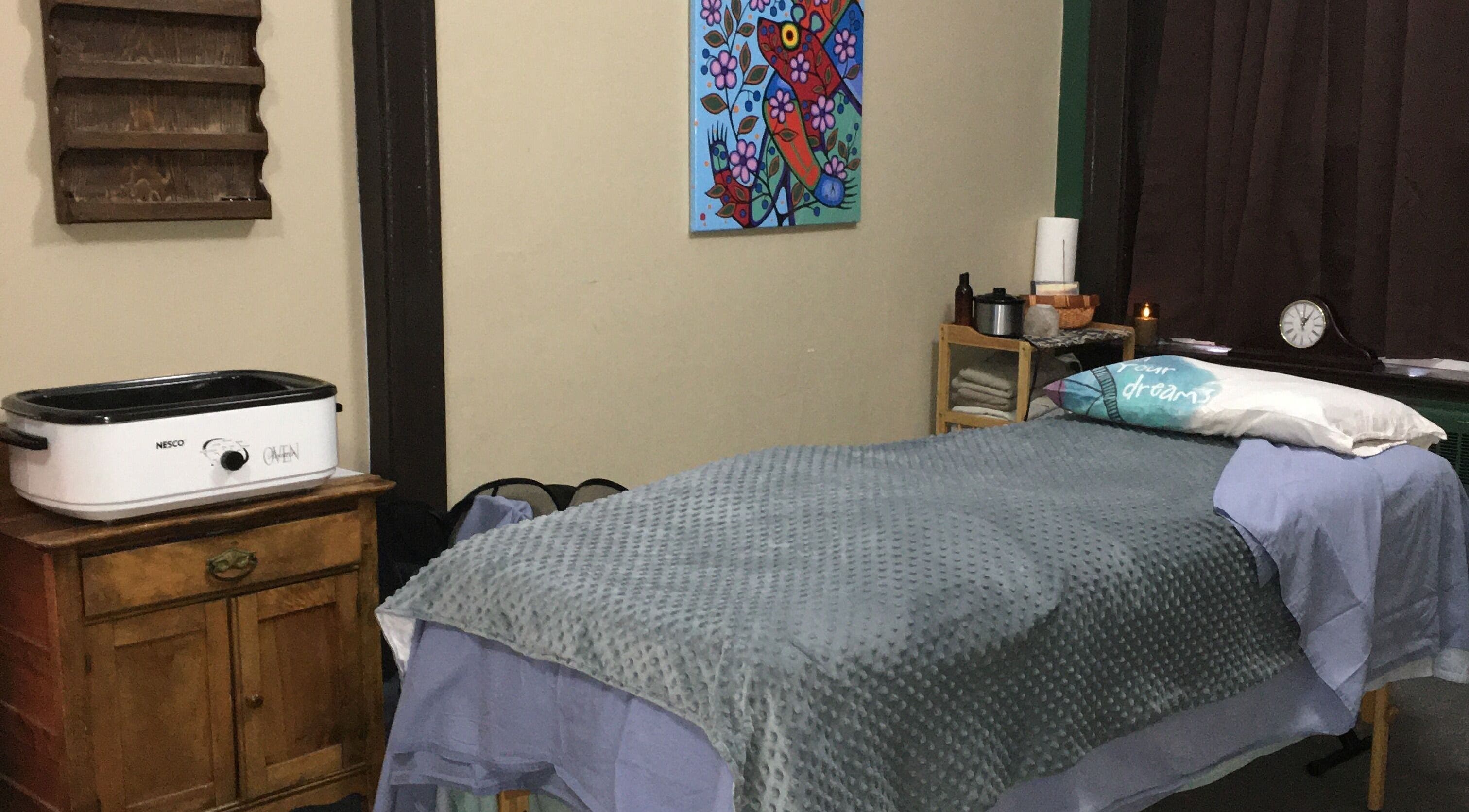Cozy massage room at Free at Last in Thunder Bay, Ontario, CA, featuring a comfortable bed and calming decor.