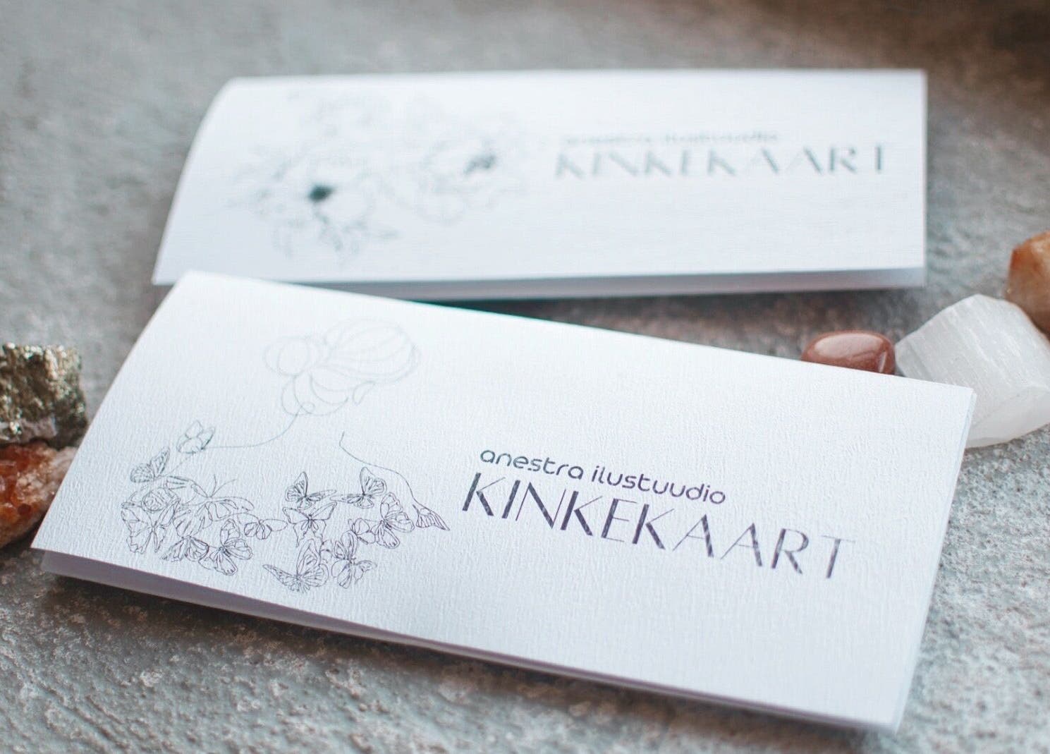 Elegant gift card for Anestra Ilustuudio, Tallinn, Harju maakond, EE, surrounded by decorative stones.