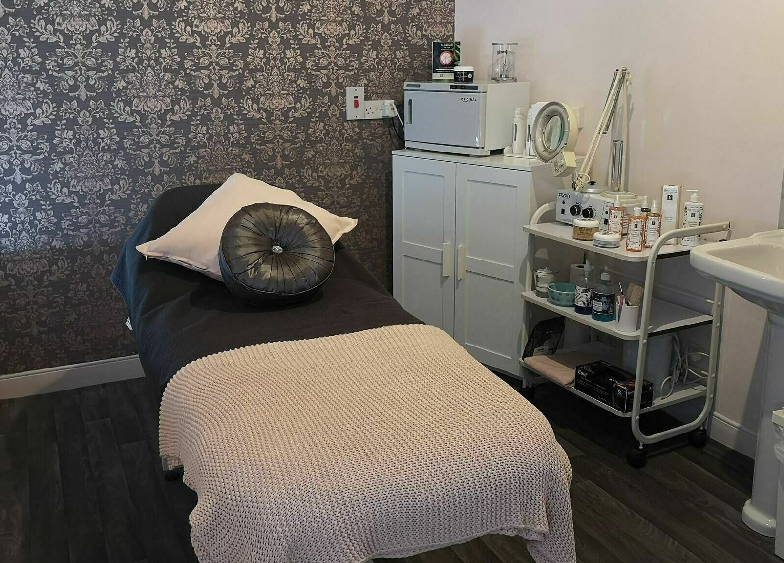 Serene treatment room at Still Beauty, Rathdowney, County Laois, IE with plush bed and skincare products.