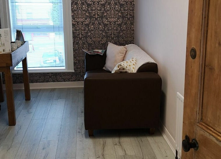Inviting seating area in Still Beauty, Rathdowney, County Laois, IE, featuring a brown sofa near a window.