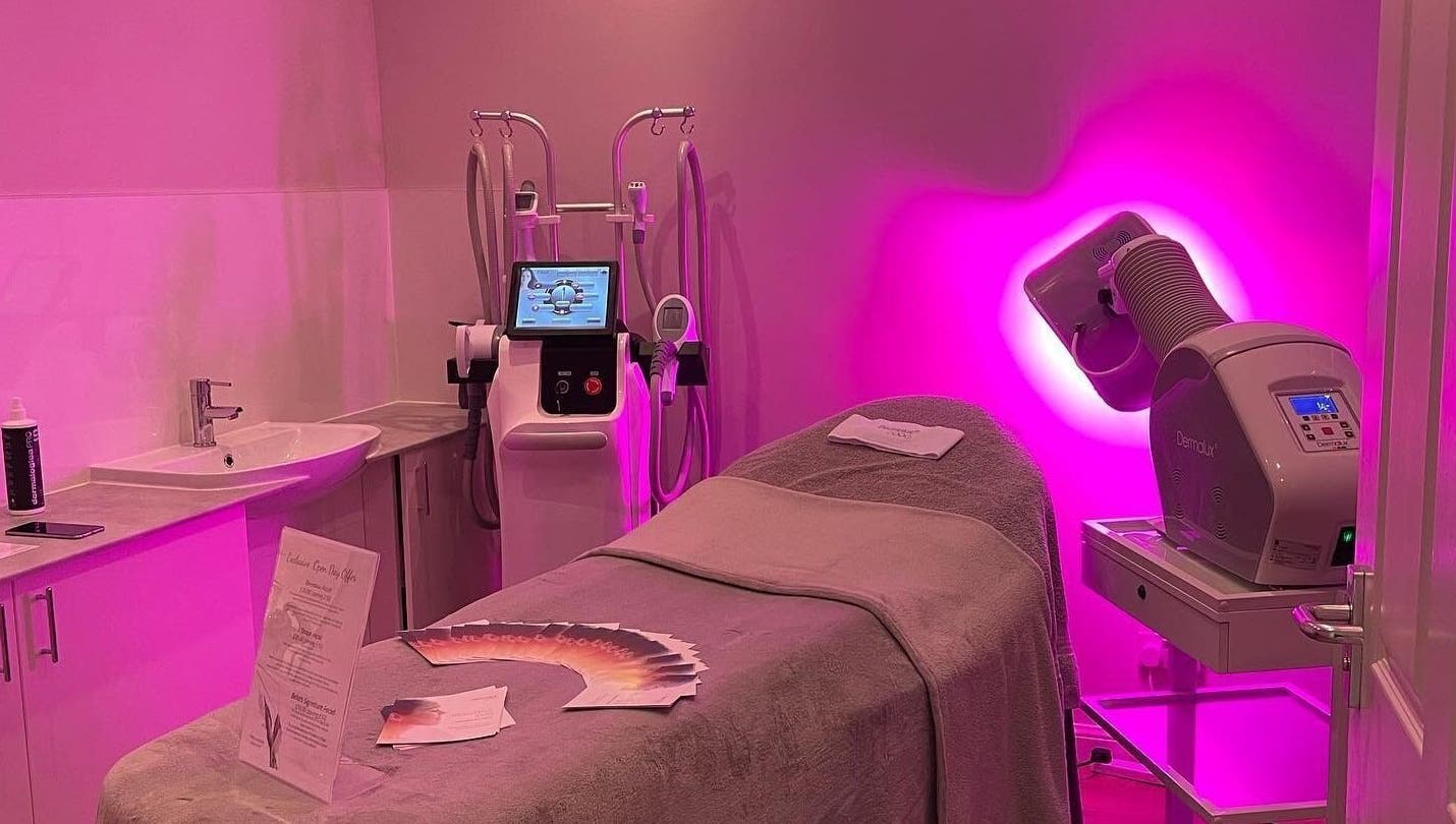 Bella Salon's serene treatment room with pink lighting in Nairn, Scotland, GB, featuring advanced beauty equipment.