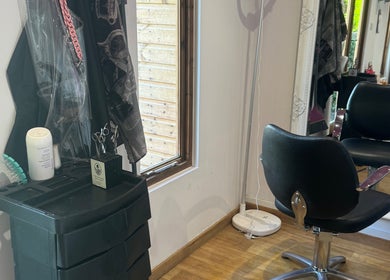 Modern salon station at Charlotte's in Glossop, England, GB, showcasing a stylish chair and mirror setup.