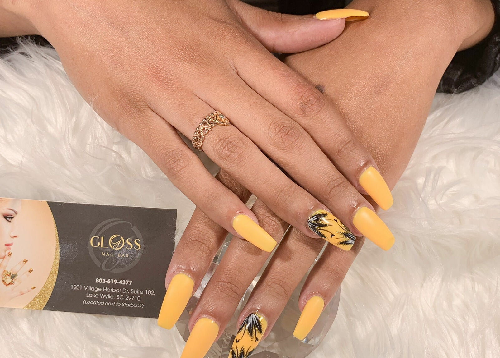 Gloss Nail Bar Clover, South Carolina, showcases elegant golden nail art on a client's hand.