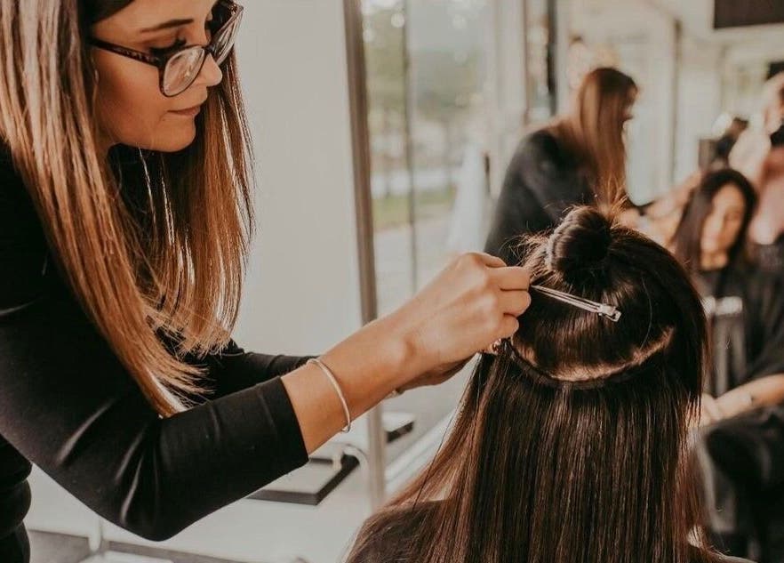 Stylist adding extensions at Fabulong Extensions by Katie Prior, Portsmouth, England, GB.