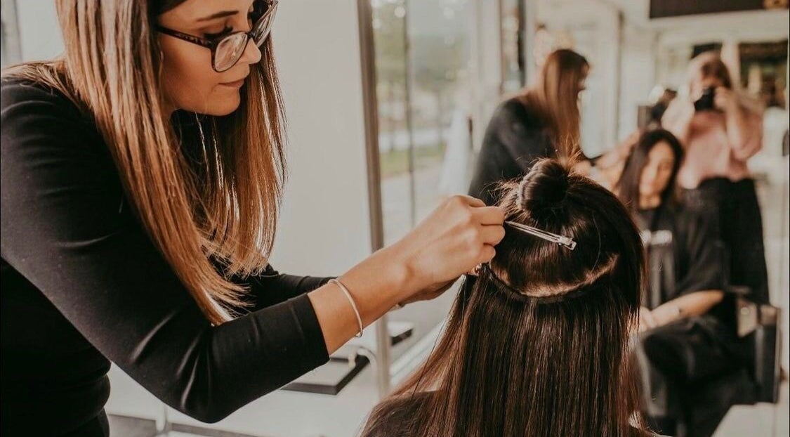 Stylist adding extensions at Fabulong Extensions by Katie Prior, Portsmouth, England, GB.