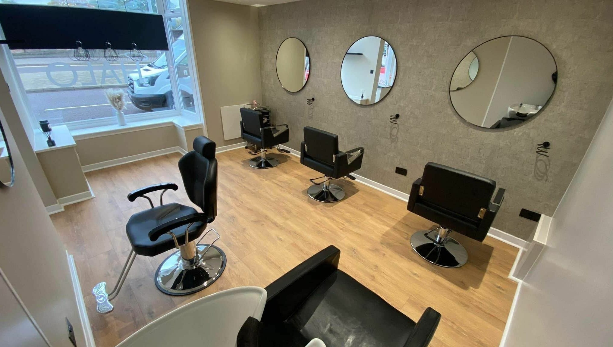 Modern interior of Ashley Allan Hair Replacement Studio in Sauchie, Scotland, GB with elegant styling chairs.