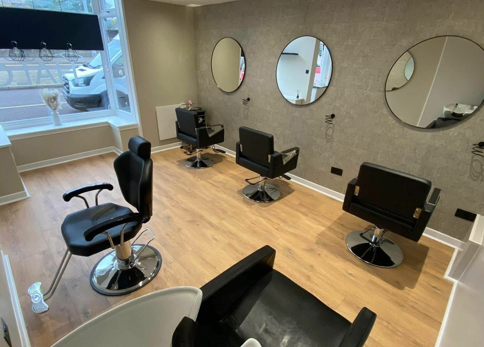 Modern interior of Ashley Allan Hair Replacement Studio in Sauchie, Scotland, GB with elegant styling chairs.