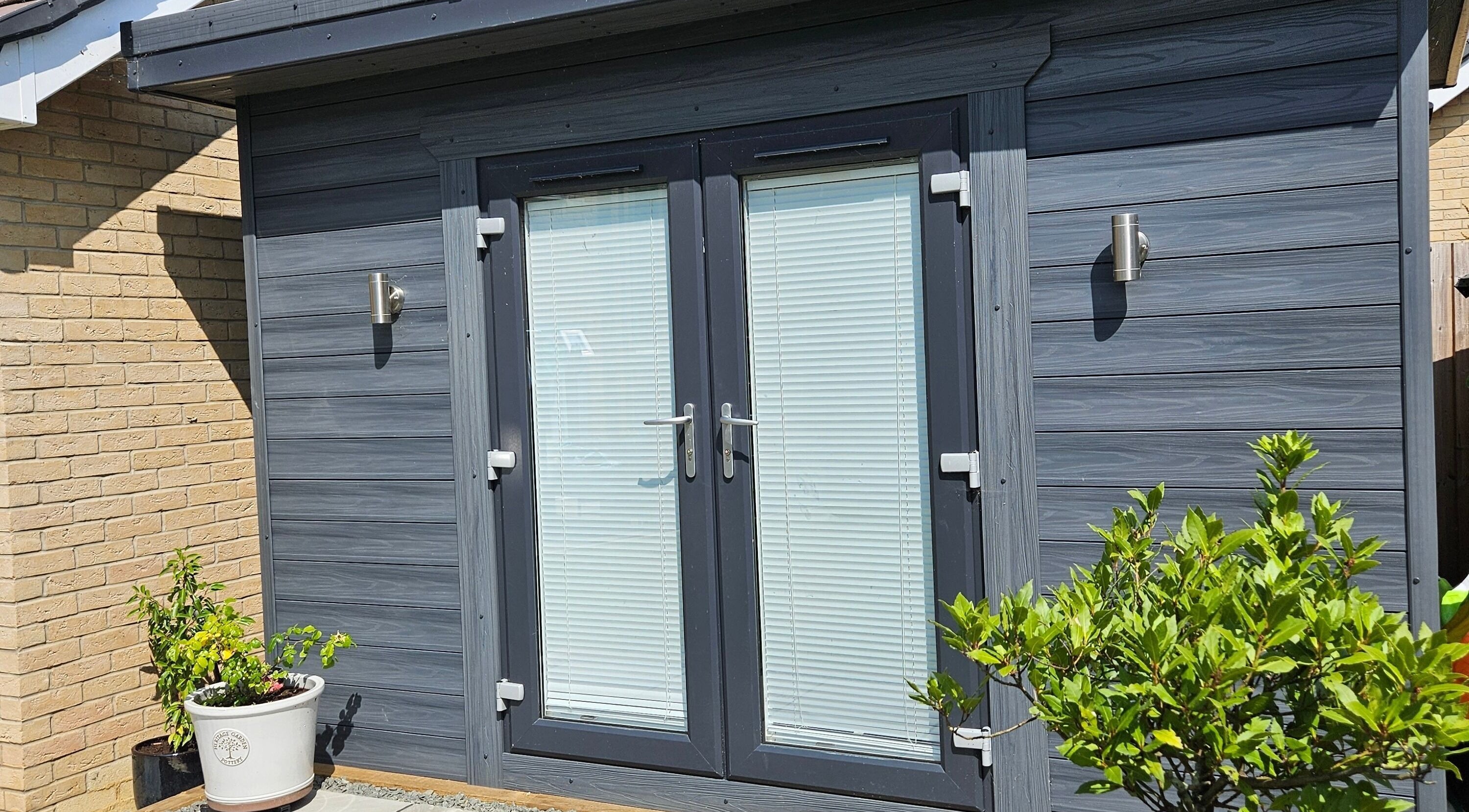 Sleek outdoor entrance of The Beauty Room, Peterborough, England, GB, with modern doors and plants.