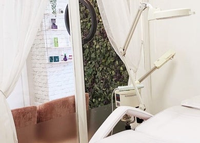 Tranquil treatment room at Eden Aesthetic Clinic, Dublin with bed, equipment, and greenery for a relaxing ambiance.