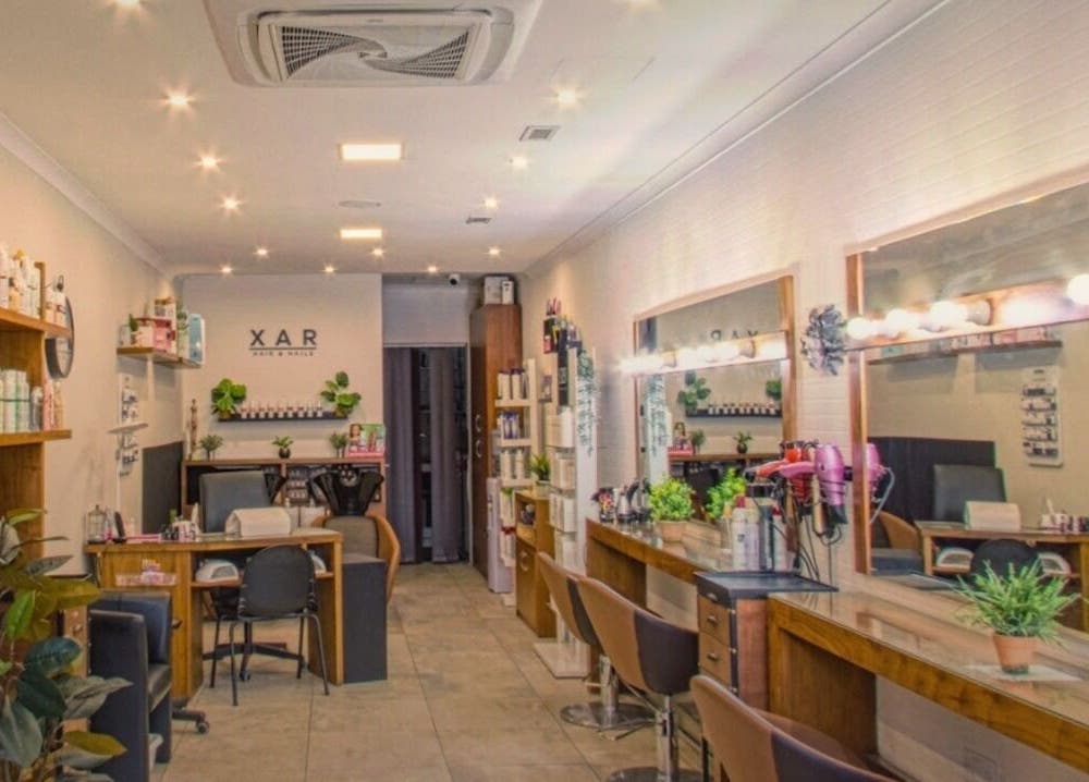 Chic interior of Xar Hair & Nails, Is-Swieqi, MT showcasing stylish salon stations with modern decor.