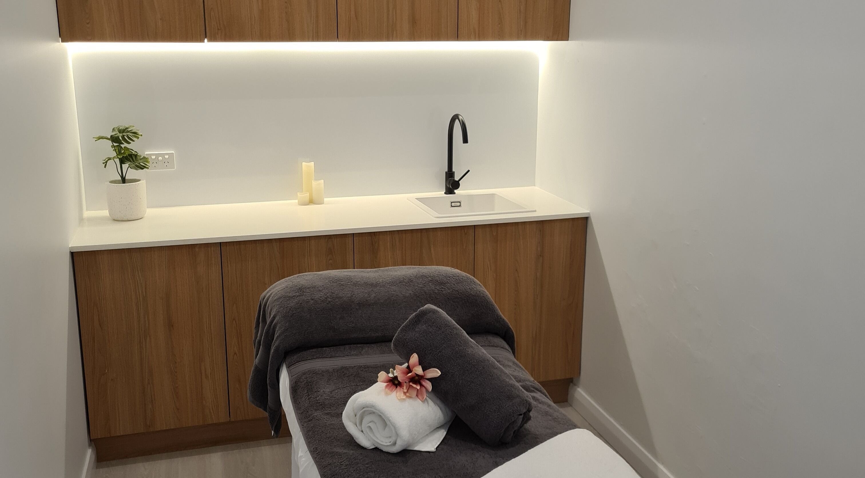 Relaxing massage room at Karisma Hair & Beauty, Blackmans Bay, Tasmania, AU, featuring a cozy table and warm decor.