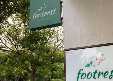 Entrance signage of Foot Rest Salon & Aesthetics in Malé, Male, MV, surrounded by lush greenery.