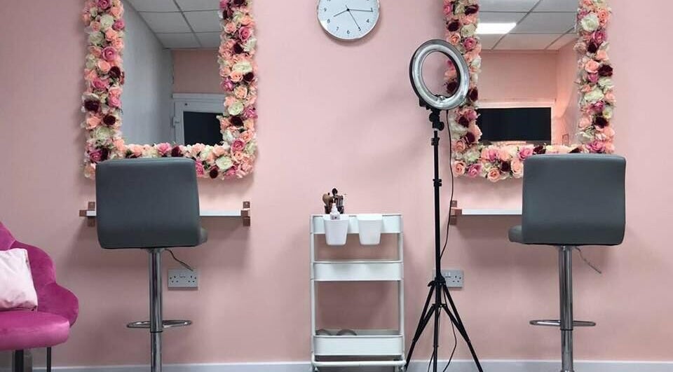 Chic pink salon interior at Olivia’s Salon, Sandbach, England, GB with floral mirrors and modern styling chairs.