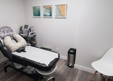Cozy treatment room at BodiMedic Contouring and Wellness, Edmonton, Alberta, CA with modern decor and comfy chair.