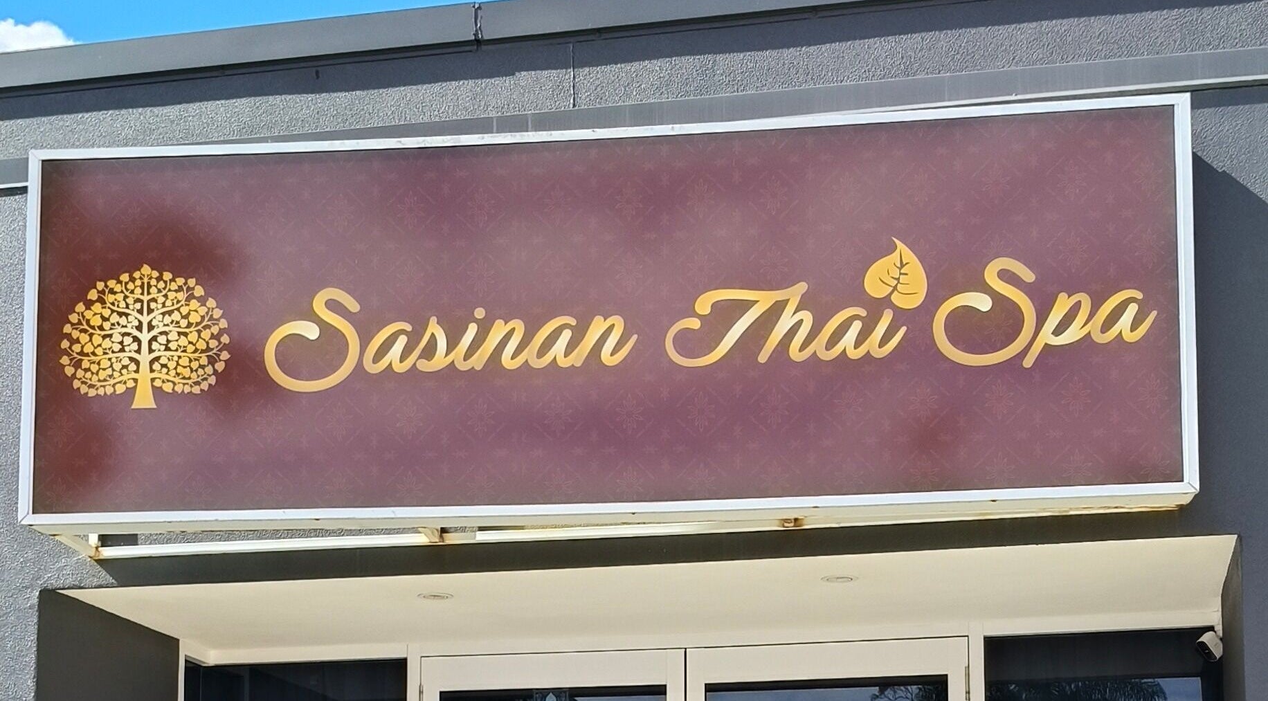 Exterior sign of Sasinan Thai Spa in Sherwood, Queensland, AU featuring gold lettering.