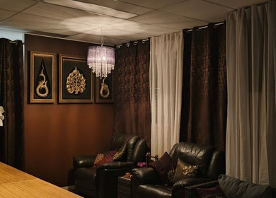 Elegant lounge at Sasinan Thai Spa in Sherwood, Queensland, AU, featuring plush chairs and decorative art.
