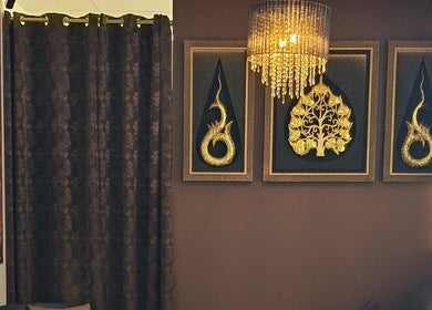 Elegant Thai decor at Sasinan Thai Spa, Sherwood, Queensland, AU, featuring intricate golden wall art.