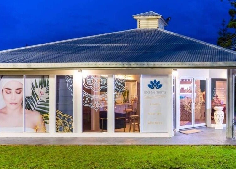 Spa Elements facade illuminated at night, Korora, New South Wales, AU. Welcoming modern design.