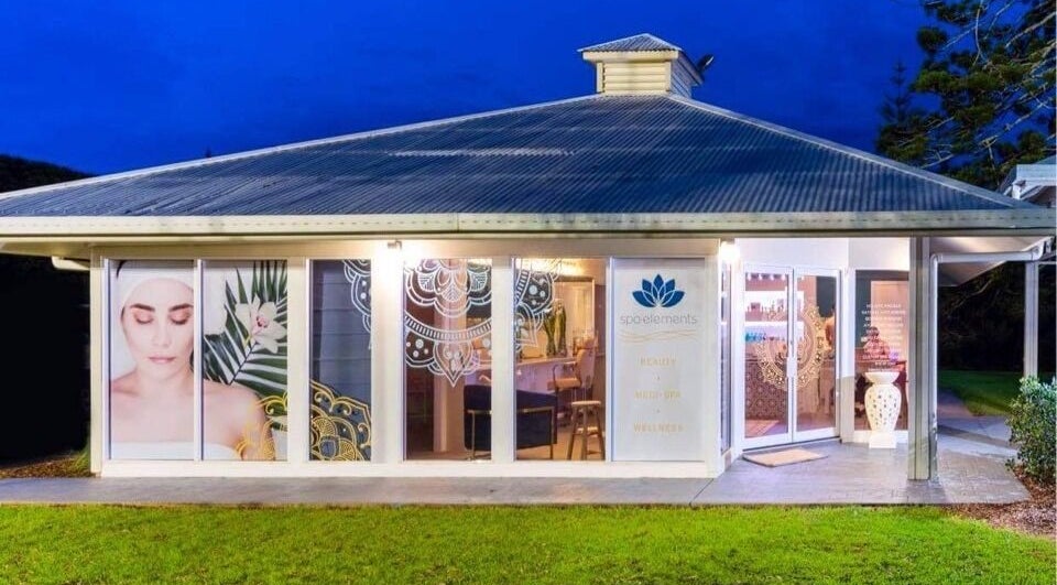 Spa Elements facade illuminated at night, Korora, New South Wales, AU. Welcoming modern design.