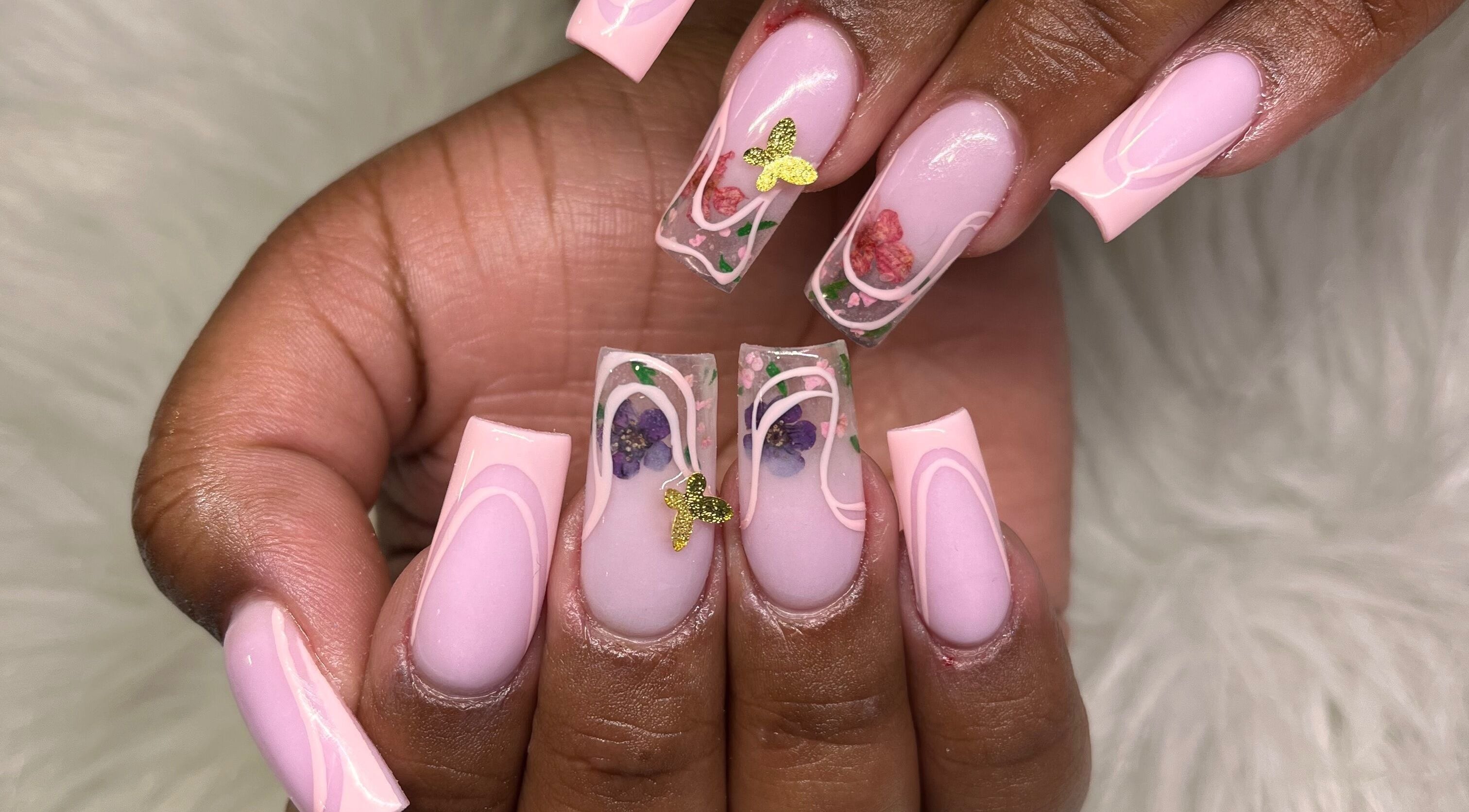 Elegant pink nails with floral and butterfly art by Nails by Pao, Lawrence, Massachusetts, US.