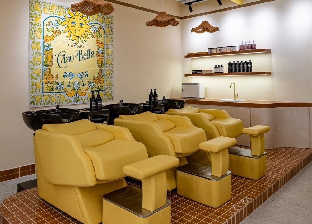 Bright shampoo area at COCOdry Bangsar, Kuala Lumpur with yellow chairs and vibrant decor.
