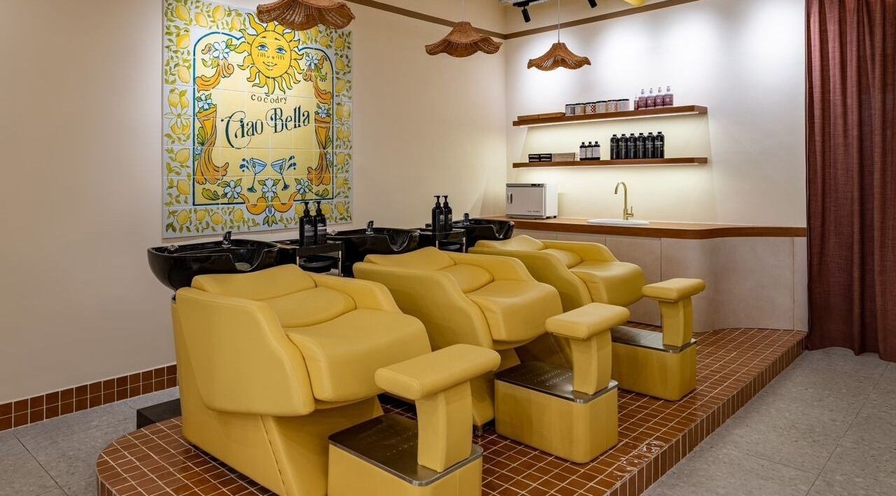 Bright shampoo area at COCOdry Bangsar, Kuala Lumpur with yellow chairs and vibrant decor.